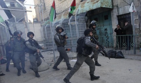 Israeli border policemen run after Palestinians during a protest against the visit of Israeli President Reuven Rivlin to the occupied West Bank city of Hebron, in Hebron February 2, 2015. 