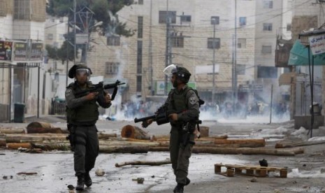 Israeli border policemen take up position during clashes with Palestinian protesters following an anti-Israel demonstration in solidarity with al-Aqsa mosque, in the West Bank city of Hebron November 21, 2014.