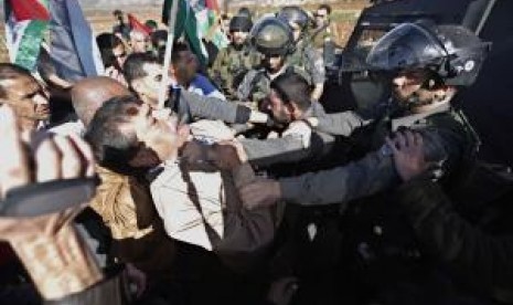 Israeli policeman shoves and grabs Ziad Abu Ein (center), a minister without portfolio, by throat on Wednesday. 