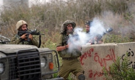 Israeli soldiers fire tear gas towards protesters during a demonstration by Palestinians protesting against the Israeli-built West Bank separation barrier and calling for the right of return for Palestinian refugees, in Tulkarem, May 31, 2014. 