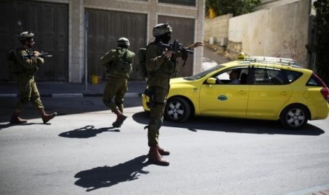 Israeli soldiers take part in an operation to locate three Israeli teens in the West Bank City of Hebron June 17, 2014.