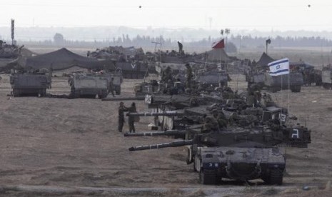 Israeli tanks and armored personnel carriers (APCs) are seen at a staging area outside the central Gaza Strip July 15, 2014.