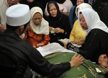 Isteri almarhum KH Zainuddin MZ, Kholilah (kanan), berdoa di dekat jenazah KH Zainuddin MZ di rumah duka, kawasan Gandaria, Jakarta Selatan, Selasa (5/7). 