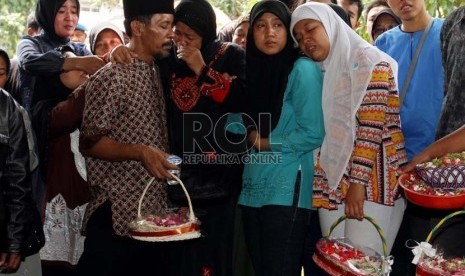   Istri almarhum Bripka Sukardi, Tirta Sari (kedua kiri) bersama putri pertamanya Dita Kardina (kedua kanan) dan putri keduanya Devi Novita (kanan) berdoa di Pemakaman TPU Kemiri, Jakarta Timur, Rabu (11/9). (Republika/Adhi Wicaksono)