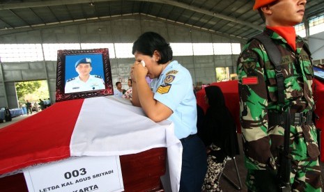 Istri almarhum Letda Kal Agus Sriyadi menangis di samping peti jenazah suaminya yang menjadi korban jatuhnya pesawat Hercules C-130 saat proses pengembalilan jenazah di Lanud Soewondo Medan, Sumatera Utara, Rabu (1/7). 