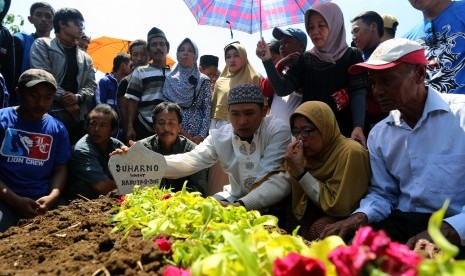 Istri dan Putra almarhum Pelatih Arema Cronus Suharno berdoa di pusara di Desa Bendosewu, Blitar, Jawa Timur, Kamis (20/8).