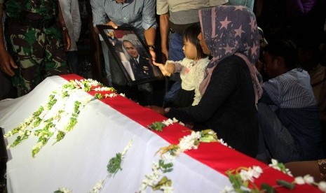 Istri dan putri korban pesawat Hercules C-130 jatuh memperhatikan foto almarhum Kapten Navigasi Riri Setiawan sebelum dimakamkan di Taman Makam Pahlawan, Kabupaten Tanah Datar, Sumatera Barat, Rabu (1/7) malam. 