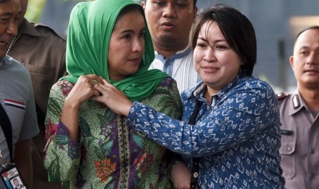 Istri Gubernur Bengkulu Lily Martiani Maddari (kiri) dikawal petugas KPK saat diamankan ke gedung KPK, Jakarta, Selasa (20/6).