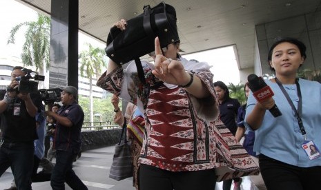 Istri Irman Gusman, Liestyana Rizal Gusman, menghindari wartawan saat mendatangi gedung KPK, Jakarta, Senin (26/9). 