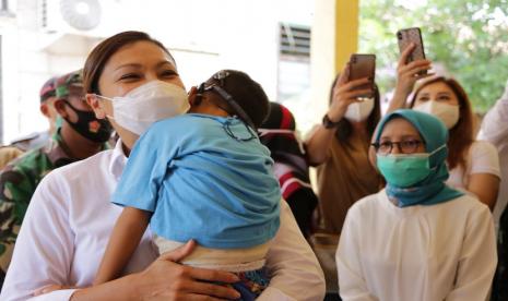 Istri Menteri Sosial Juliari Batubara, Grace Batubara menggendong seorang anak dalam sebuah acara. Kementerian Sosial RI bergerak cepat mempercepat penanganan stunting di Indonesia melalui program Bantuan Pangan Non Tunai (BPNT)/Program Sembako. 