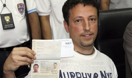 Italian Luigi Maraldi whose stolen passport was used by a passenger boarding a missing Malaysian airliner, shows his passport as he reports himself to Thai police at Phuket police station in Phuket province, southern Thailand Sunday, March 9, 2014. Maraldi