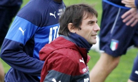 Italian national soccer team's Mario Balotelli runs past coach Antonio Conte, during a training session with the team at the Coverciano Training Center, near Florence, central Italy, Monday, Nov.10, 2014. Italy will play Croatia in Milan on Sunday in a Eur