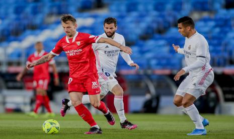 Ivan Rakitic dari Sevilla, kiri, berebut bola dengan Nacho dari Real Madrid pada pertandingan sepak bola La Liga Spanyol antara Real Madrid dan Sevilla di stadion Alfredo di Stefano di Madrid, Spanyol, Minggu, 9 Mei 2021.