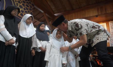 Iwan Bule memberikan santunan pada anak yatim. 