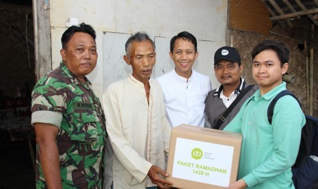 IZI menyerahkan bantuan ke salah satu warga di Muara Gembong