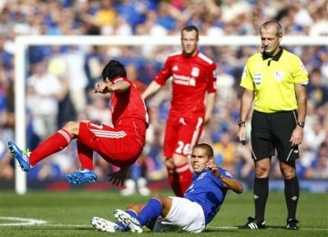 Jack Rodwell (tengah), pemain Everton, melakukan tackling pada striker Liverpool, Luis Suarez (kiri), di laga derby Merseyside.