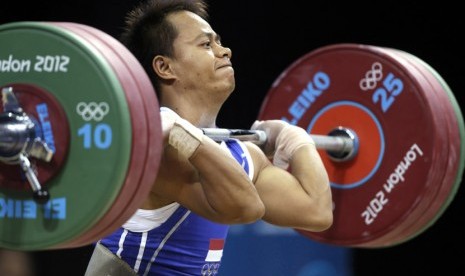   Jadi Setiadi berusaha mengangkat beban saat berkompetisi pada cabang angkat besi Grup B kelas 56 kg di Olimpiade London di Excel, Ahad (29/7). (Mike Groll/AP)