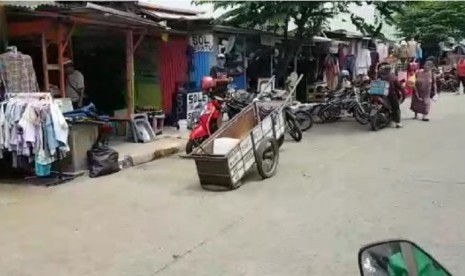 Jalan Dewi Sartika menuju Stasiun Depok Baru, dipenuhi barang-barang para pedagang kaki lima.