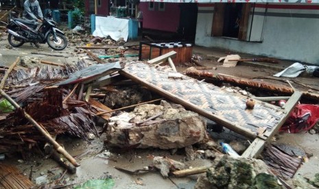 Jalan Raya Anyer, Ahad (23/12), sulit dilalui kendaraan roda empat karena terhambat puing.