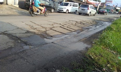 Jalan raya Babelan, Kecamatan Babelan, Kabupaten Bekasi, berlubang-lubang dan membuat pengendara terpaksa memperlambat laju kendaraannya. 