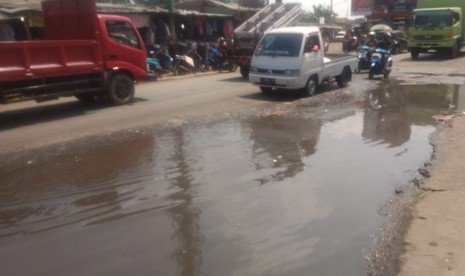 Jalan raya di depan pasar Cileungsi,  Cileungsi,  Kabupaten Bogor kondisnya saat ini rusak dan tergenang oleh air, Senin (20/5).