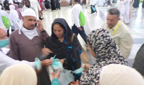 Jamaah asal India membagikan masker gratis kepada jamaah haji di Masjid Nabawi jelang maghrib, Selasa (15/8). 