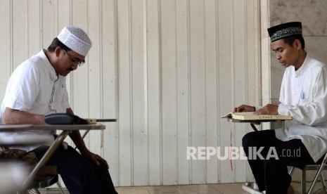  Jamaah belajar membaca AlQuran bersama ustaz sebelum Shalat Jumat di Masjid Istiqlal, Jakarta, Jumat (15/9). 