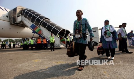 Jamaah Calon Haji asal Garut bergegas menaiki pesawat pada keberangkatannya di Bandara Soekarno-Hatta, Tanggerang, Banten, Kamis (8/3).