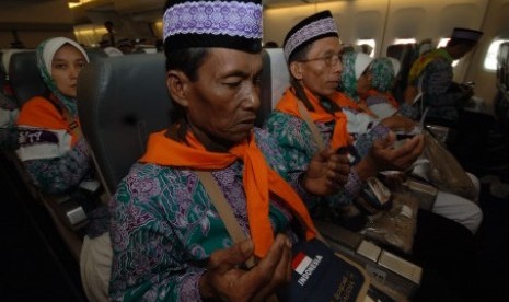 Jamaah calon haji berdoa di pesawat sebelum terbang ke Tanah Suci