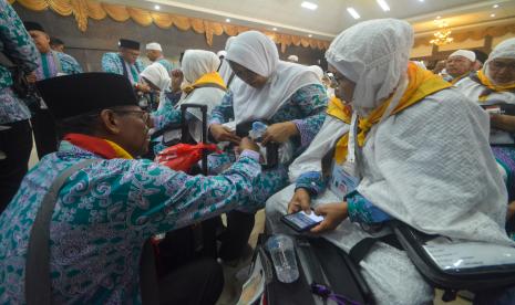 Jamaah calon haji kelompok terbang (kloter) 1 embarkasi haji Padang memasang gelang haji setibanya di Asrama Haji Tabing, Padang, Sumatera Barat, Jumat (3/6/2022). Sebanyak 393 jamaah calon haji asal Padang masuk ke Asrama Haji Tabing sebelum diberangkatkan ke Tanah Suci pada Sabtu, 4 Juni 2022. Seorang Calon Jamaah Haji Payakumbuh Wafat Sebelum Berangkat