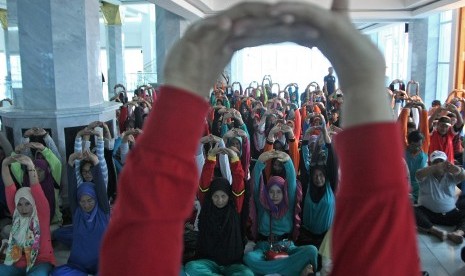 Jamaah calon haji Kendari dipandu pegawai KKP Kendari mengikuti latihan olah raga yang dapat dilakukan dalam pesawat, di Masjid Al Alam, Kendari, Sulawesi Tenggara. Kemenag Sultra Prioritaskan Lansia Sebagai Calon Jamaah Haji 2023