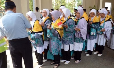  Jamaah calon haji kloter 5 menunggu pemeriksaan paspor saat pemberangkatan di Asrama Haji Pondok Gede, Jakarta, Senin (24/8).    (Republika/WIhdan)