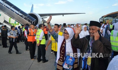 Jamaah calon haji melambaikan tangan kepada keluarga mereka, menjelang keberangkatan kloter pertama embarkasi Padang, di Bandara Internasional Minangkabau (BIM), Padangpariaman, Sumatera Barat, Selasa (17/7). 