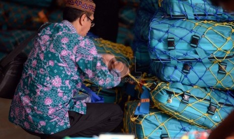 Jamaah calon haji memasang pita koper di Asrama Haji Pondok Gede, Jakarta, Kamis (10/9).