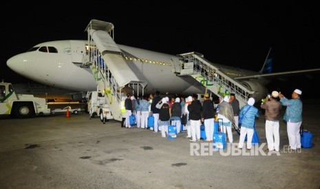 Jamaah calon haji yang tergabung dalam kelompok terbang (kloter) 1 asal Kabupaten Tegal antre memasuki pesawat di Bandara Adi Soemarmo, Boyolali, Jawa Tengah, Selasa (17/7) dini hari. 