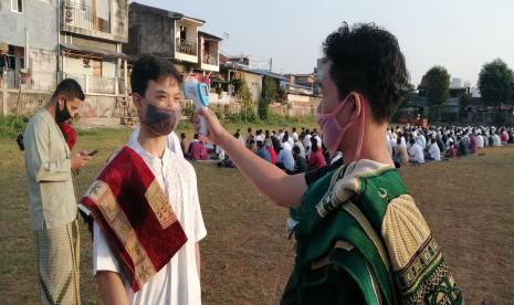 Jamaah diperiksa suhu tubuh sebelum menunaikan sholat di lapangan samping Mapolsek Palmerah, Jakbar, Jumat (31/7). 