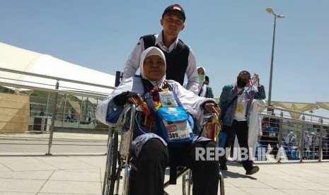 Petugas haji mendorongkan kursi roda jamaah calon haji dari Embarkasi Padang setibanya di Bandara AMA Madinah, Selasa (17/7).