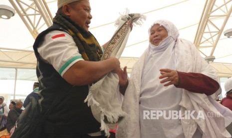 Jamaah haji embarkasi SOC 48 asal Tegal, Widjah Daklan (59 tahun) terpaksa mengenakan tiga rangkap mukena dan sajadah karena tasnya tak muat lagi.