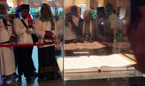 Jamaah haji Indonesia mendengarkan penjelasan dari seorang guide tentang isi Museum Al Quran Madinah, Jumat (26/7). Museum ini menyimpan berbagai koleksi mushaf Al Quran dan yang semua berusia lebih dari 1000 tahun lalu. 