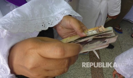 Melihat <em>Money Exchange</em> Tahun 1979 di Makkah. Foto ilustrasi:   Jamaah haji Indonesia menukarkan rupiah mereka ke riyal di tempat penukaran uang di Madinah, tak jauh dari pintu 21 Masjid Nabawi, Sabtu (12/8). Jamaah asal Depok embarkasi JKS kloter 38 Yani Eson Sutisna mengatakan ia menukar Rp 2 juta sebagai persiapan ke Makkah. Uang Rp 2 juta tersebut ditukar dengan 560 riyal.