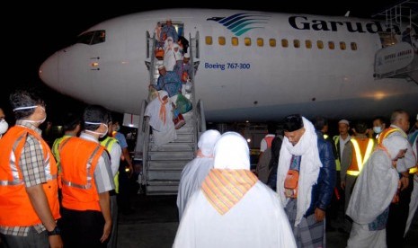   Jamaah haji asal Aceh turun dari pesawat saat tiba di Bandara Internasional Sultan Iskandar Muda, Aceh Besar.