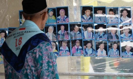  Jamaah Haji melihat foto hasil jepretan tukang foto di kawasan Asrama Haji Pondok Gede, Jakarta, Rabu (2/9).   (Republika/ Yasin Habibi)