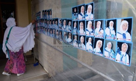 Jamaah Haji melihat foto hasil jepretan tukang foto di kawasan Asrama Haji Pondok Gede, Jakarta, Rabu (2/9).  (Republika/ Yasin Habibi)