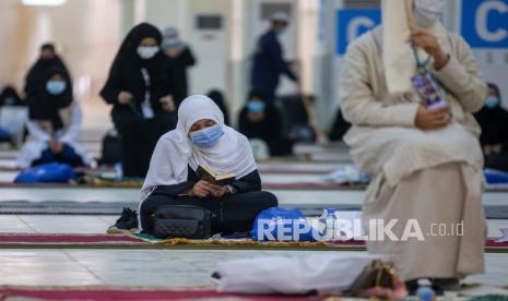 Benarkah Muslimah Berihram Dilarang Bercadar? . Jamaah haji membaca Alquran di dalam Masjid Namira di Arafah mengenakan masker dan menjaga jarak sosial untuk melindungi diri mereka terhadap virus corona di dekat kota suci Mekah, Arab Saudi, Kamis (30/7/2020).