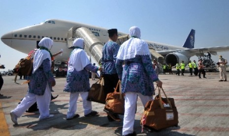 Jamaah haji menaiki pesawat yang akan membawa mereka ke Tanah Suci.