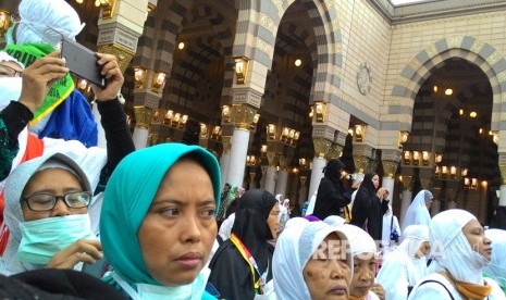  Jamaah haji perempuan Indonesia menunggu dengan tertib  untuk masuk ke raudhah, Ahad (30/7). Jamaah haji harus rela menunggu dua jam sebelum pintu raudhah dibuka. 