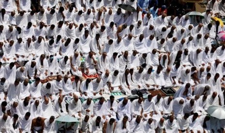 Jamaah haji shalat sembeari mengenakan ihram.