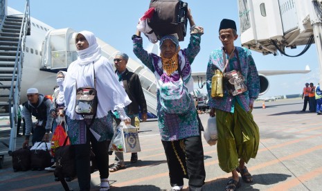 Jamaah haji yang tergabung dalam kelompok terbang (kloter) pertama tiba di Bandara Internasional Juanda Surabaya di Sidoarjo, Jawa Timur, Minggu (18/9). 