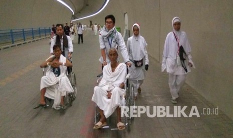  Jamaah haji lanjut usia didorong dengan kursi roda karena keletihan usai melontar jumrah di Mina, Senin (12/9). (Republika/ Amin Madani)