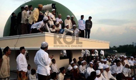 Jamaah Masjid Jami Al-Musari'in Basmol dan santri Al-Hidayah mengamati posisi hilal di Kembangan Utara, Jakarta Barat, Senin (8/7).  (Republika/Agung Supriyanto)